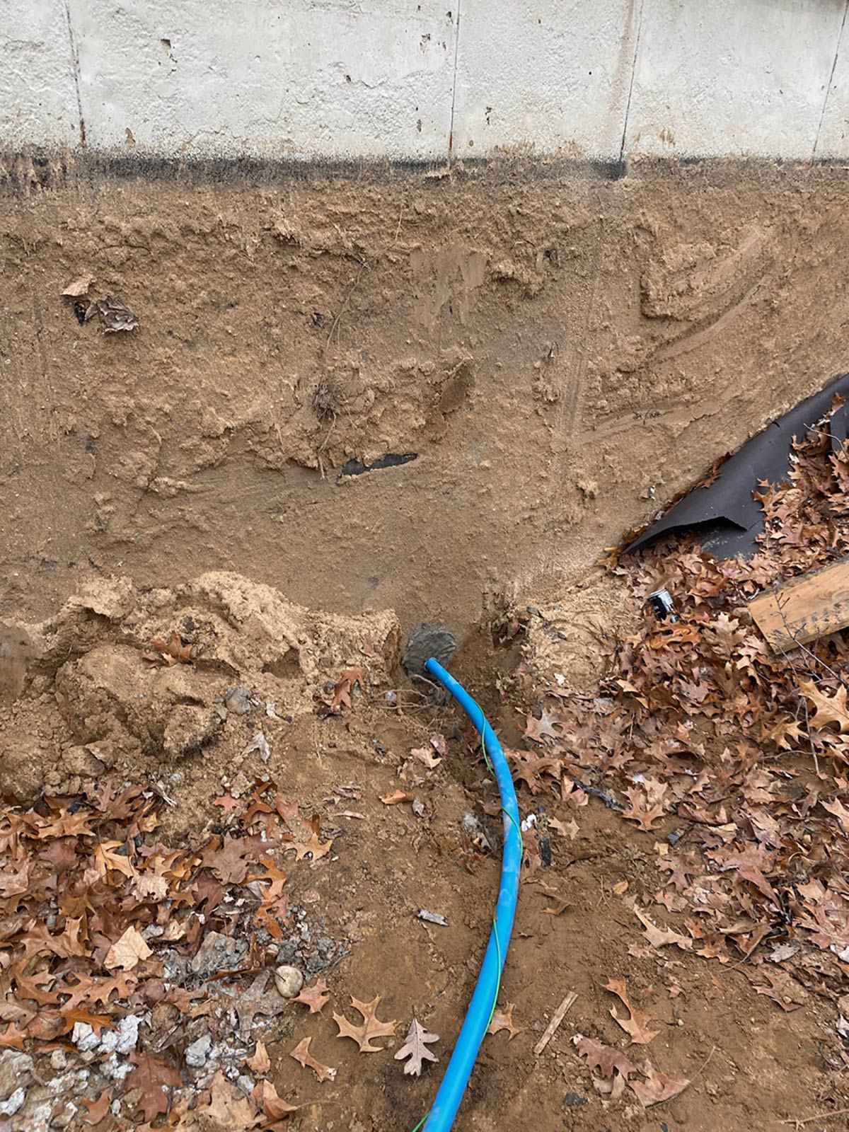 excavation for plumbing line going into cement wall
