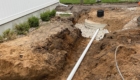 pipe in trench going to cement container for water management system